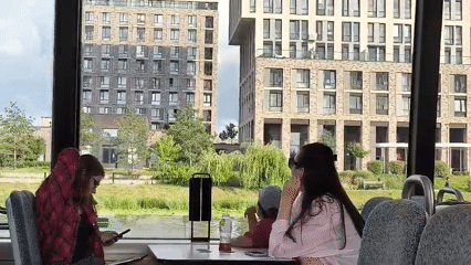 Bus passengers drift past Moscow's riverside on a quiet afternoon