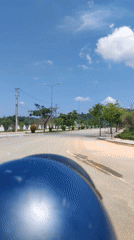 Helmet-wearing rider travels paved road in Bo Y, Vietnam