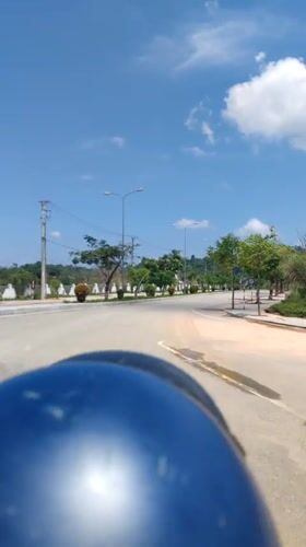 Helmet-wearing rider travels paved road in Bo Y, Vietnam