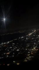 Passenger films nighttime city lights from airplane over Kuta