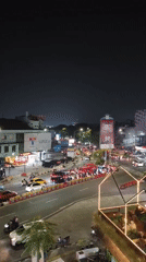 Nighttime traffic flows through a busy Depok intersection