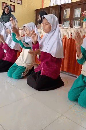 Girls clap together in Indonesian classroom