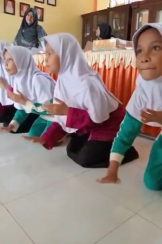 Girls clap together in Indonesian classroom
