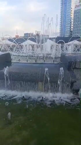 Fountain running in central Minsk plaza near the Gate towers
