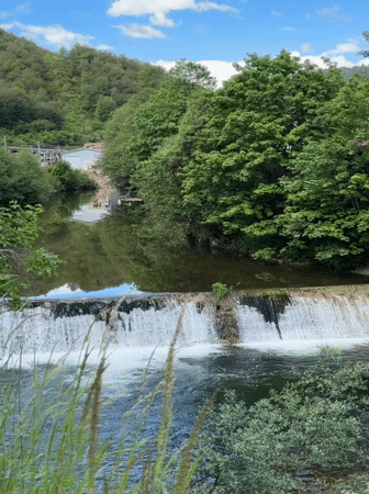 Tourist documents Rudozem waterfall and bronze goat sculpture