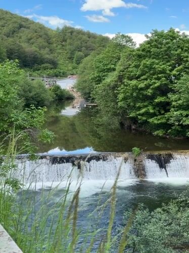 Tourist documents Rudozem waterfall and bronze goat sculpture