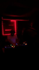 Late-night DJ set observed in red-lit Tel Aviv venue