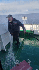 Bearded man cleans boat deck in Russian waters