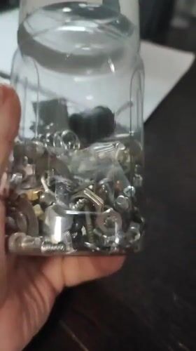 Jar of mixed metal hardware held up for a look