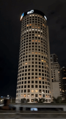 Illuminated cylindrical building with 'IEBd' signage observed in Buenos Aires