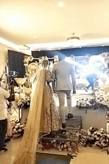 Indoor wedding ceremony with bride, groom on decorated stage