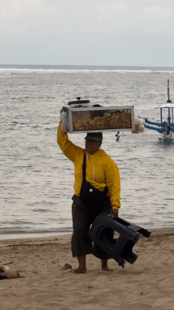 Beach vendors serve customers despite warning flags in Denpasar
