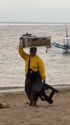 Beach vendors serve customers despite warning flags in Denpasar