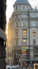 Sunny Moscow street scene features domed building, passing bus