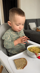 Child enjoys mealtime in high chair in Odintsovo home