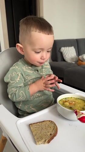 Child enjoys mealtime in high chair in Odintsovo home