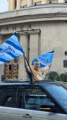 Man displays blue-white flags from SUV sunroof in Saint Petersburg