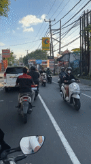Motorcycle rider navigates morning traffic in Kuta Selatan