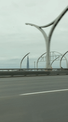 Vehicle travels Saint Petersburg highway past decorative arched structures