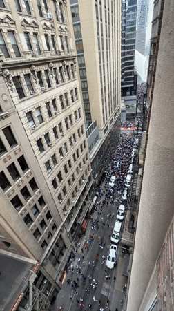Large crowd and vehicle procession fill Manhattan street mid-morning