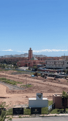 Marrakesh cityscape with pink mosque, mountains captured on video