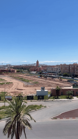 Marrakesh cityscape with pink mosque, mountains captured on video