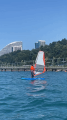 Windsurfing off the Khostinskiy shore on a blue sailboard