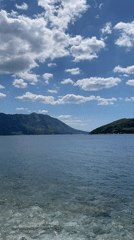 Sailboat spotted on calm waters near mountainous coast