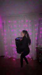 Woman carries glowing speaker in purple-lit room in Russia