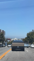 Light brown Cybertruck cruising a tree-lined LA street