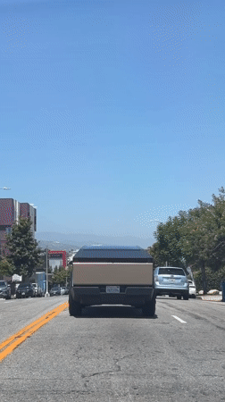 Light brown Cybertruck cruising a tree-lined LA street