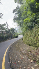 Motorcyclist rides through green mountains in Baturiti, Indonesia