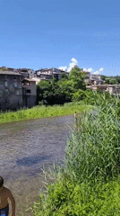 Children wade in shallow river in French village