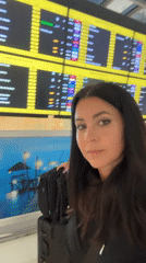 Woman travels through Thai airport with ornate dragon artwork