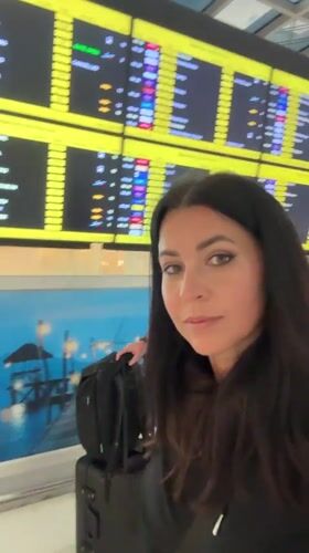 Woman travels through Thai airport with ornate dragon artwork