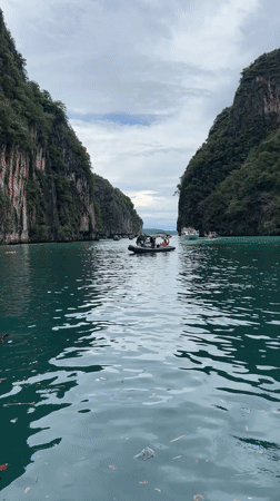 Boats navigating Ao Nang's turquoise waters beneath karst cliffs
