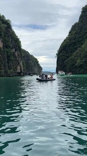 Boats navigating Ao Nang's turquoise waters beneath karst cliffs