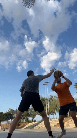 Outdoor pickup basketball in Tarragona, with a skatepark sunset