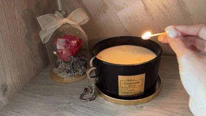 Person lights premium candle while writing in notepad