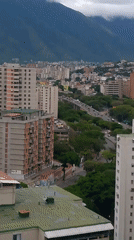 Aerial views capture Caracas cityscape with mountain backdrop