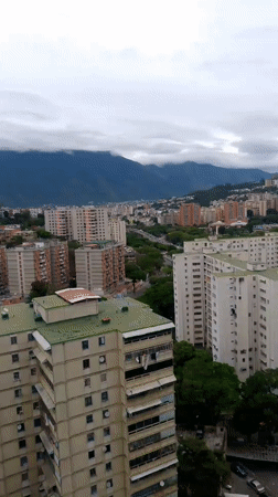 Aerial views capture Caracas cityscape with mountain backdrop