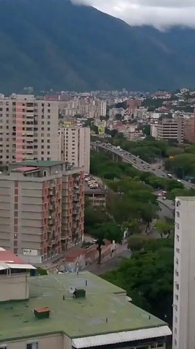 Aerial views capture Caracas cityscape with mountain backdrop