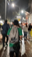 Nighttime crowd event in Mexico City, green shirts and wet streets