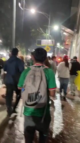 Nighttime crowd event in Mexico City, green shirts and wet streets