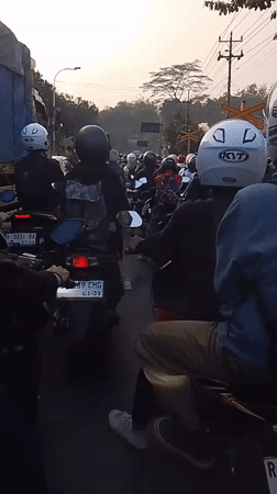 Motorcycle traffic stacks up at a Pasirmuncang railway crossing