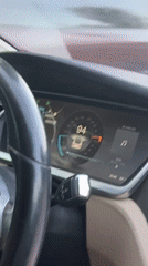 Tesla interior at 94 mph, driver smiling at camera
