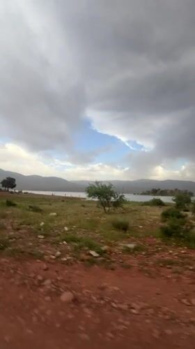 Visitor documents scenic views of Bin El Ouidane reservoir, Morocco