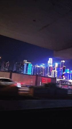 Nighttime drive captured through illuminated Yuzhong District skyline