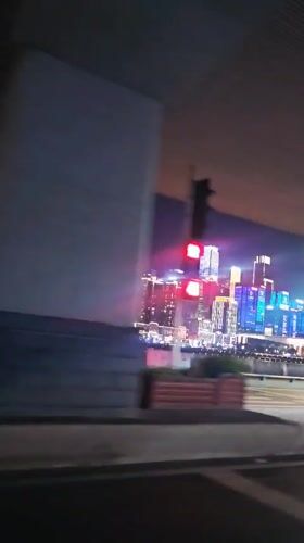Nighttime drive captured through illuminated Yuzhong District skyline