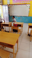 Boys play on classroom desks in Simpangjaya school